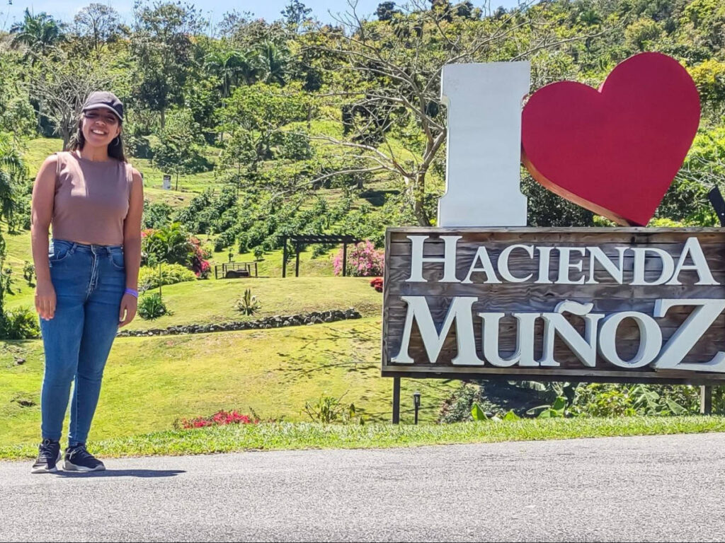 The author Vanessa posing for a photo beside the signage in Hacienda Muñoz