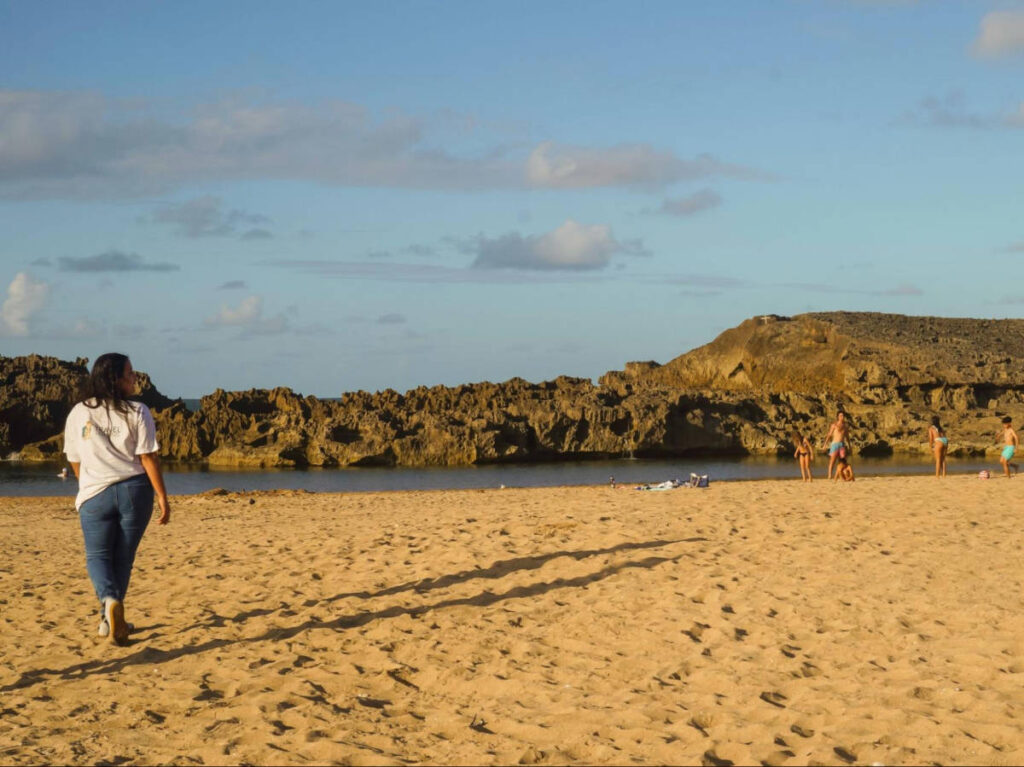The author Vanessa Ramos walking o the sand in Puerto Nuevo Beach at sunset