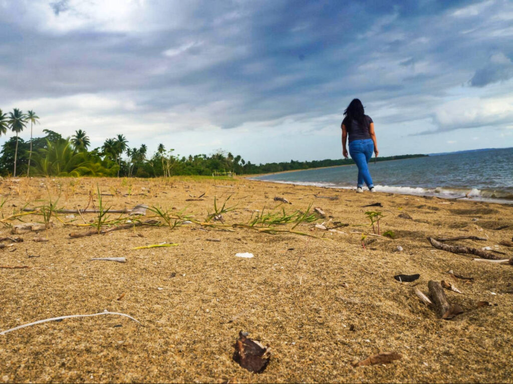 The author Vanessa Ramos walking along the shoreline in Añasco