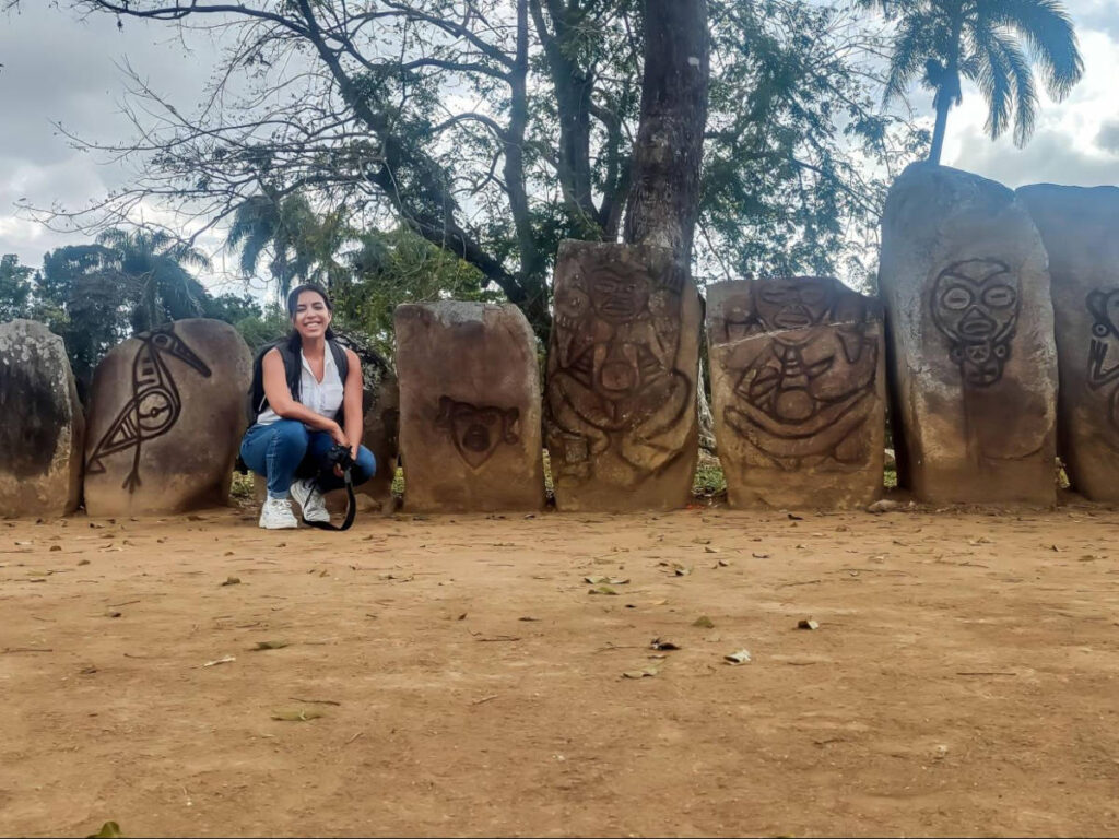 The author Vanessa Ramos posing for a photo with the petroglyphs in Caguana