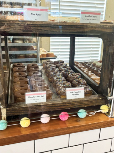 A display case with variety of donuts at Five Daughters Bakery