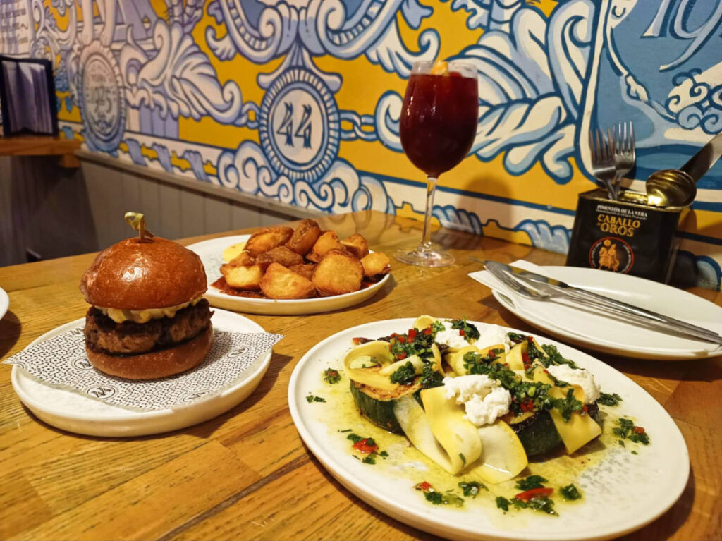 Plates of variety of dishes and a burger on a table in Bar 44