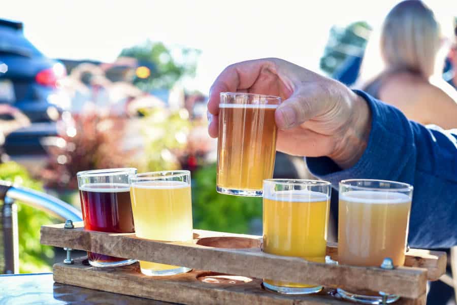 Man's hand grabbing a drink from the variety of seasonal craft beers