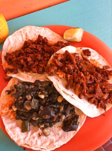 Closeup view of the three vegetarian tacos on a red plate