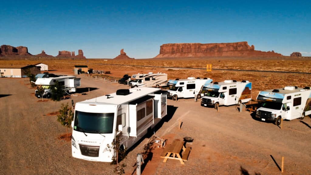 Camper Vans parked in Utah campground with a scenic view in the background