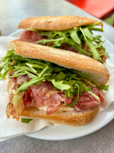Delizie D’italia's Venezia panini, a plate with a sandwich filled with meat and greens