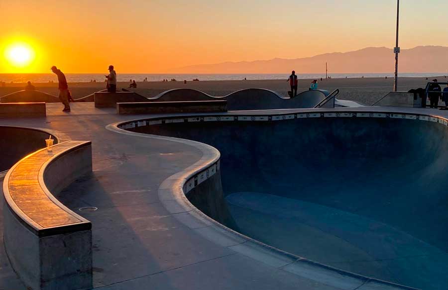 View of skaters in Venice Skate Park at sunset