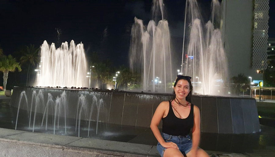 View of the author sitting and a fountain on her background