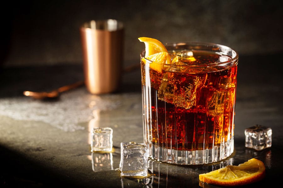 A cocktail on glass with lemon on it