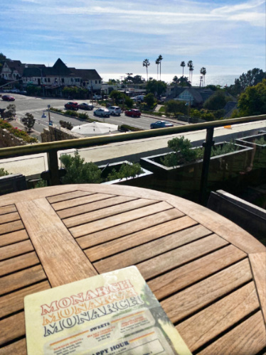 View of Monarch's menu on a wooden table at the rooftop paio