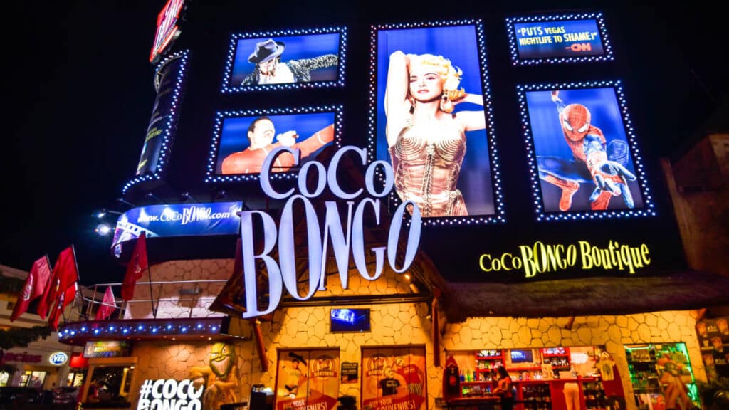 Exterior view of Coco Bongo with illuminated posters above the entrance