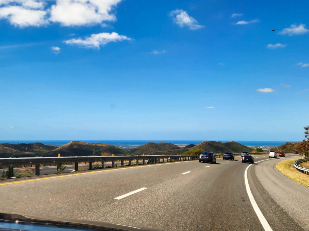 Cars driving wiith amazing views in Puerto Rico on a sunny day
