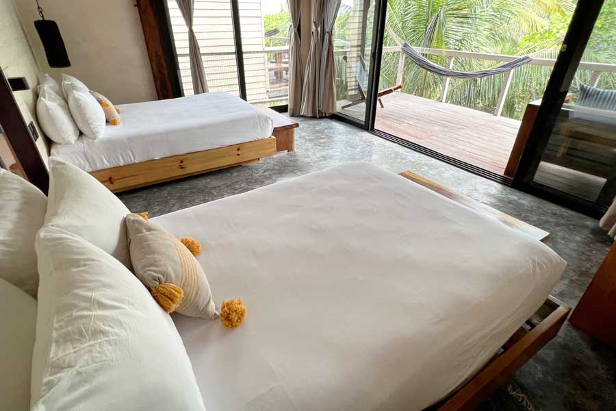Two beds inside a room with a balcony in Villa Pescadores