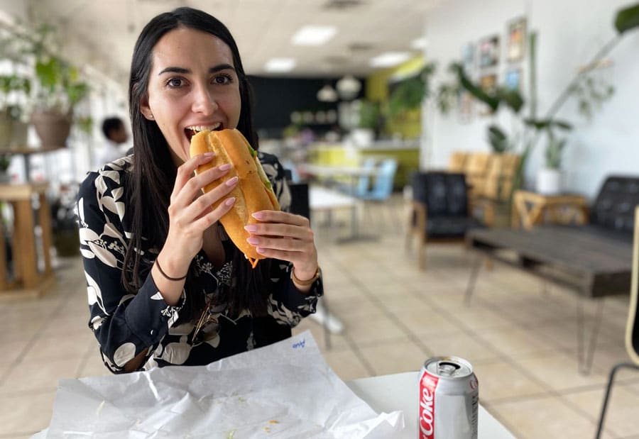 Clara having a first bite of tofu banh mi in Vinh Xuong Bakery
