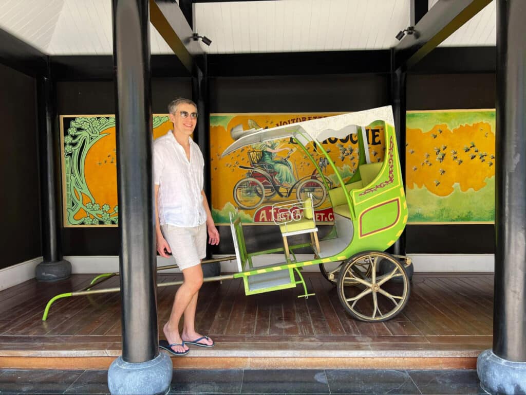 Nate and a vintage trishaw on his background