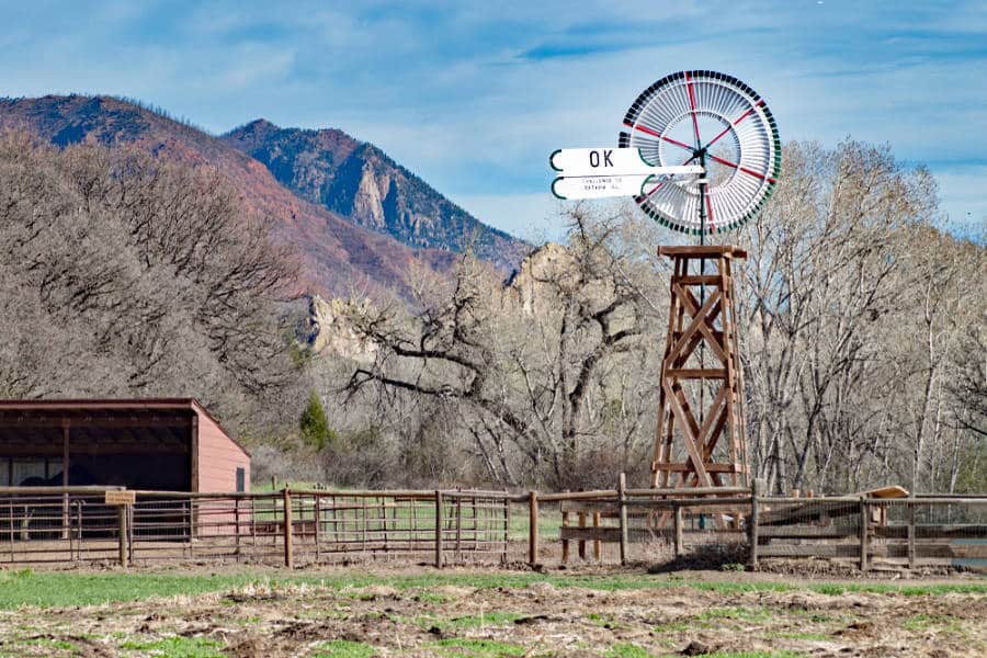 View of the vintage windmills with the mountain views behind at Rock Ledge Ranch