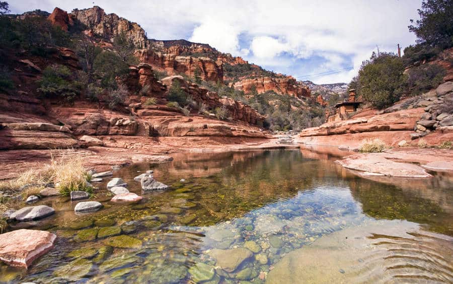 View of the clear river water surrounded by red rock mountains