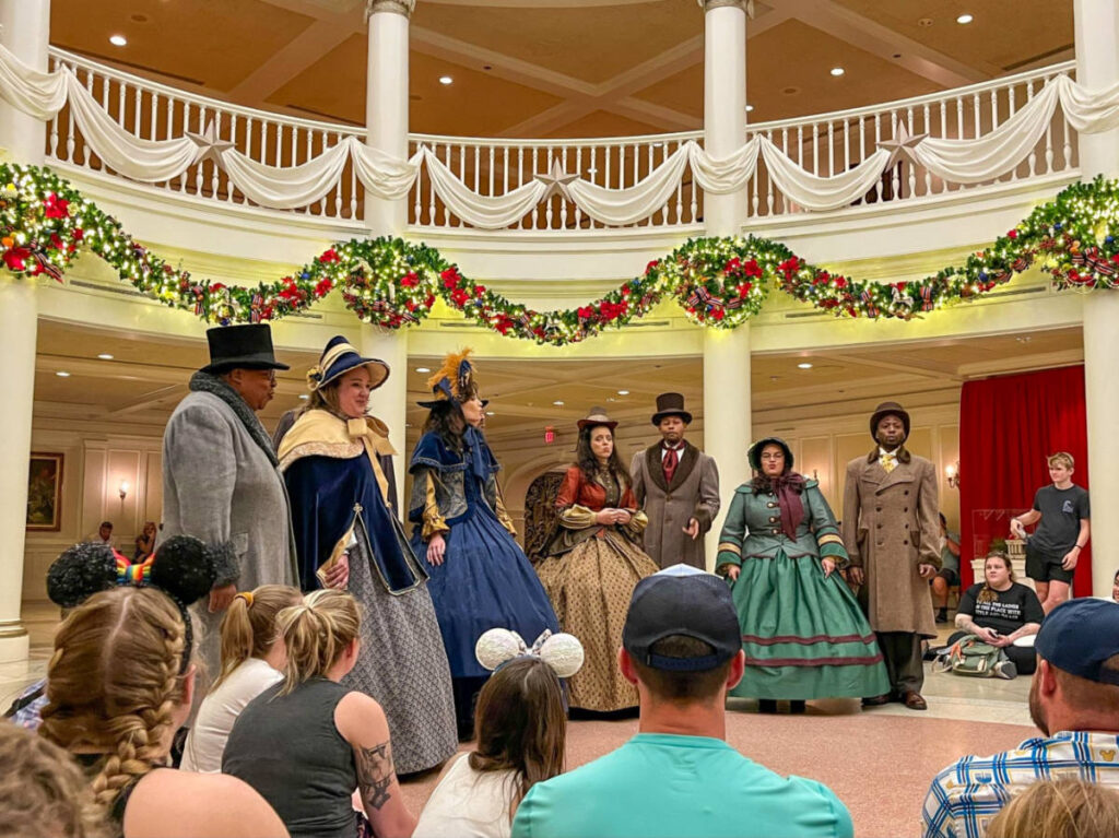 Voices of Liberty singing on stage in their Dickens Carolers outfits