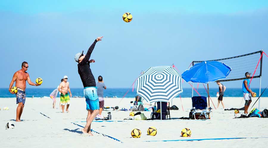 People playing volleyball under the clear blue sky in Mission Beach