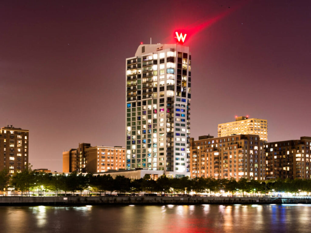 Exterior view of the W Hoboken Hotel from across the water at night