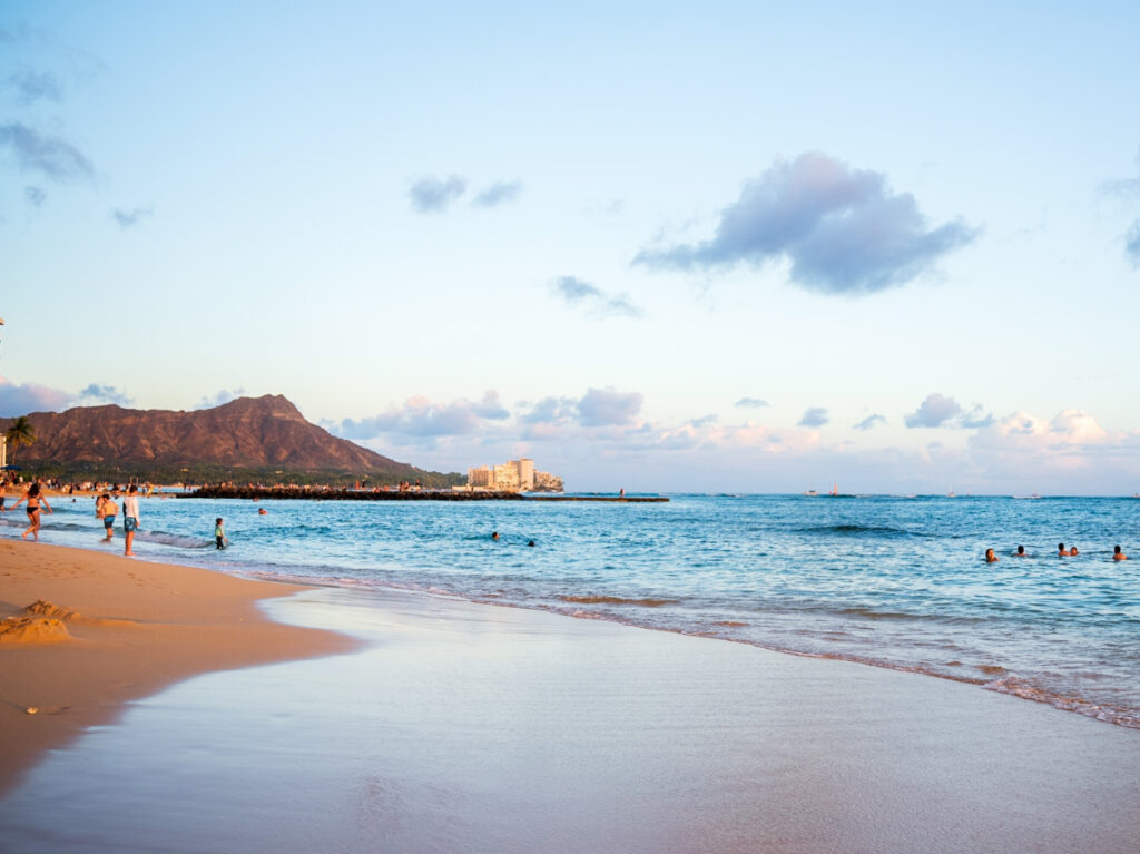 View of the people enjoying at the Waikiki Beach with the Diamondhead crater in the background at sunrise
