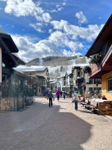 People walking around Vail Village with scenic mountain views