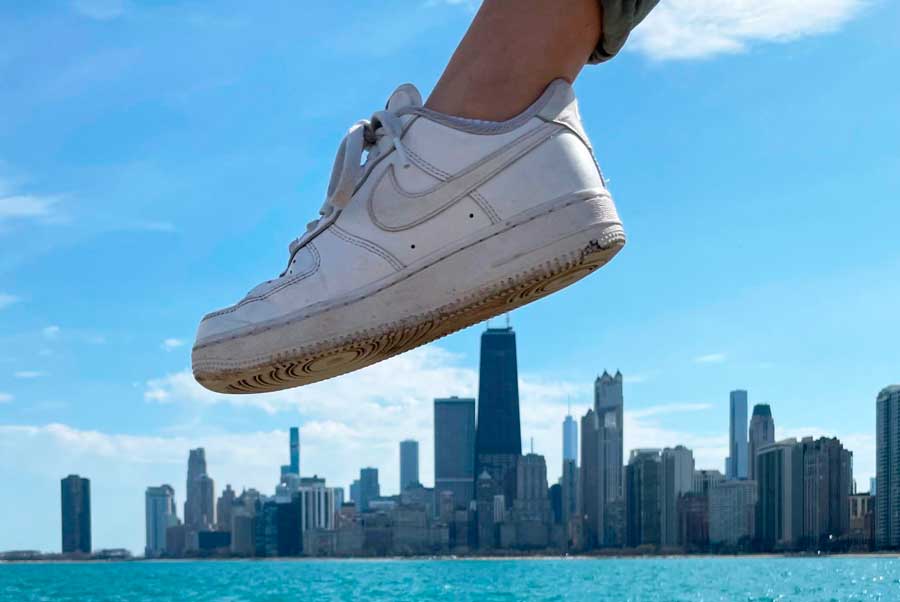 The author's shoes making an illusion of stepping the buildings on the city