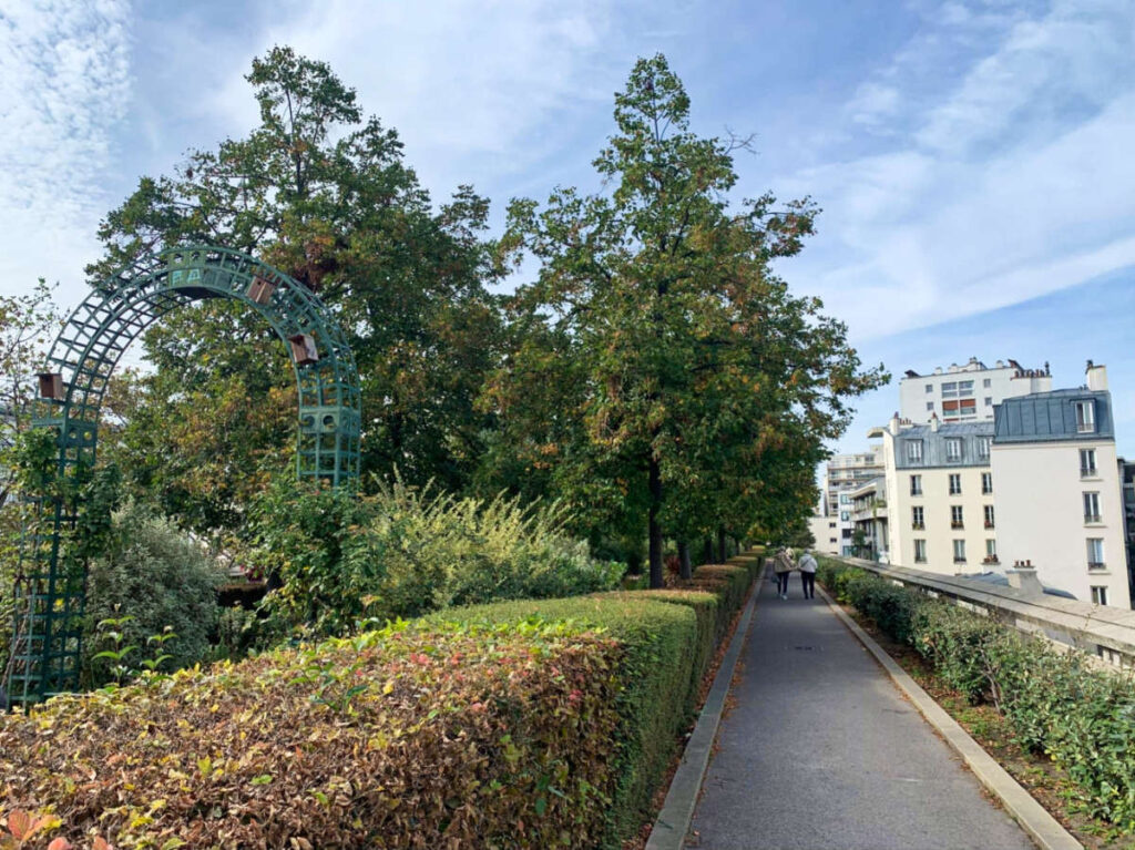 View of the walkway surrounded by greenery in Coulée Verte René-Dumont