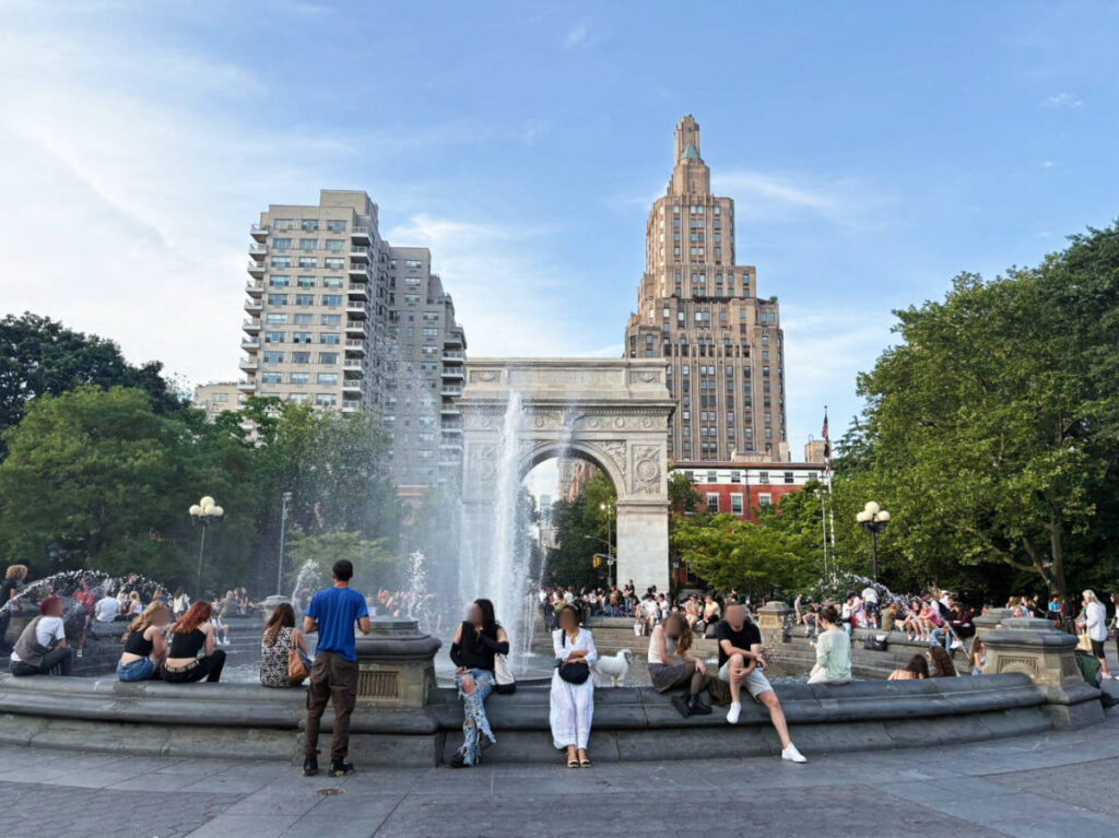 View of people around a water fountain in Washington Square Park