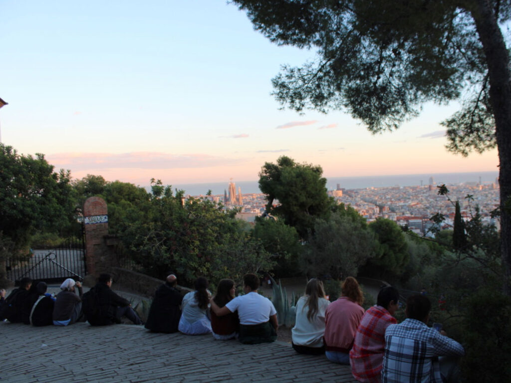 People sitting and watching the sunset at Park Güell in Gràcia