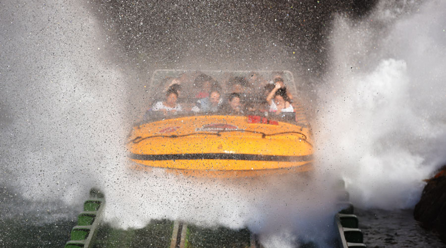 View of people riding a water ride being splashed by water