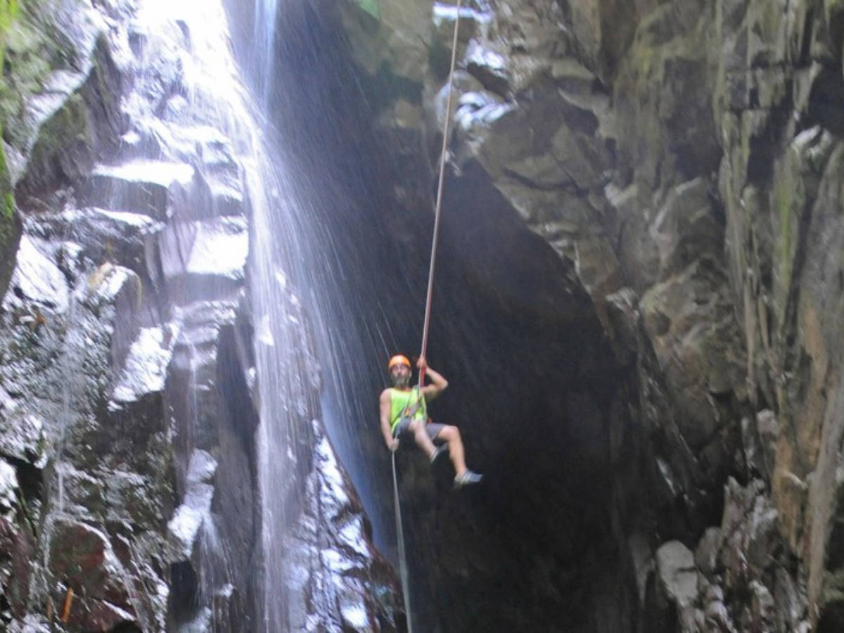 A man trying the waterfall rappelling