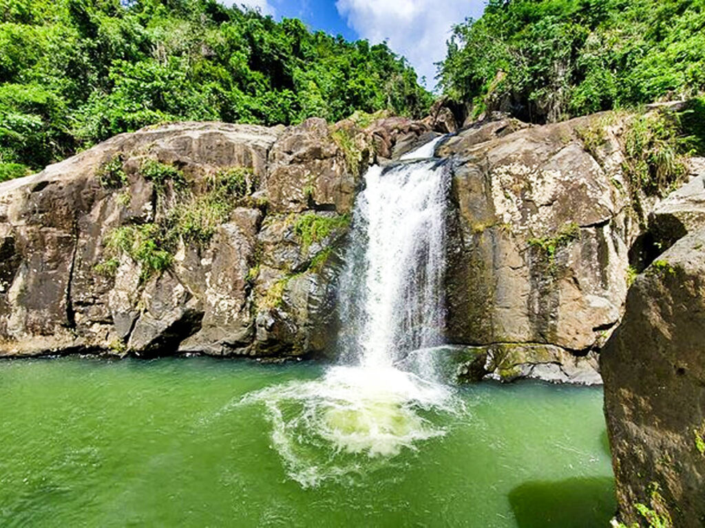 View of the cascading down waterfall in El Yunque on a sunny day