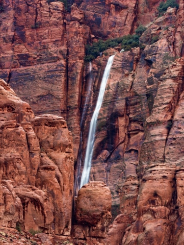 A waterfall on the red rocks behind the Kayenta Art Village