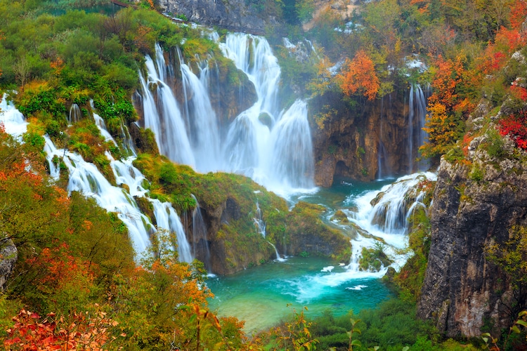 The waterfalls of Plitvice National Park surrounded by Autumn foliage