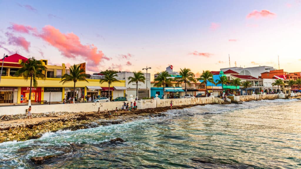 View of the colorful buildings near the ocean in Cozumel at sunset