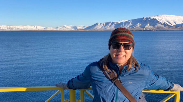 The author ALaura Falin smiling for a photo at the waterfront in Iceland