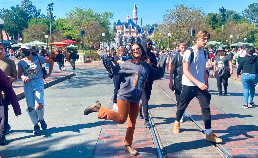 The author McKenna Mobley posing for a photo near the trolley tracks on Main Street in Disneyland