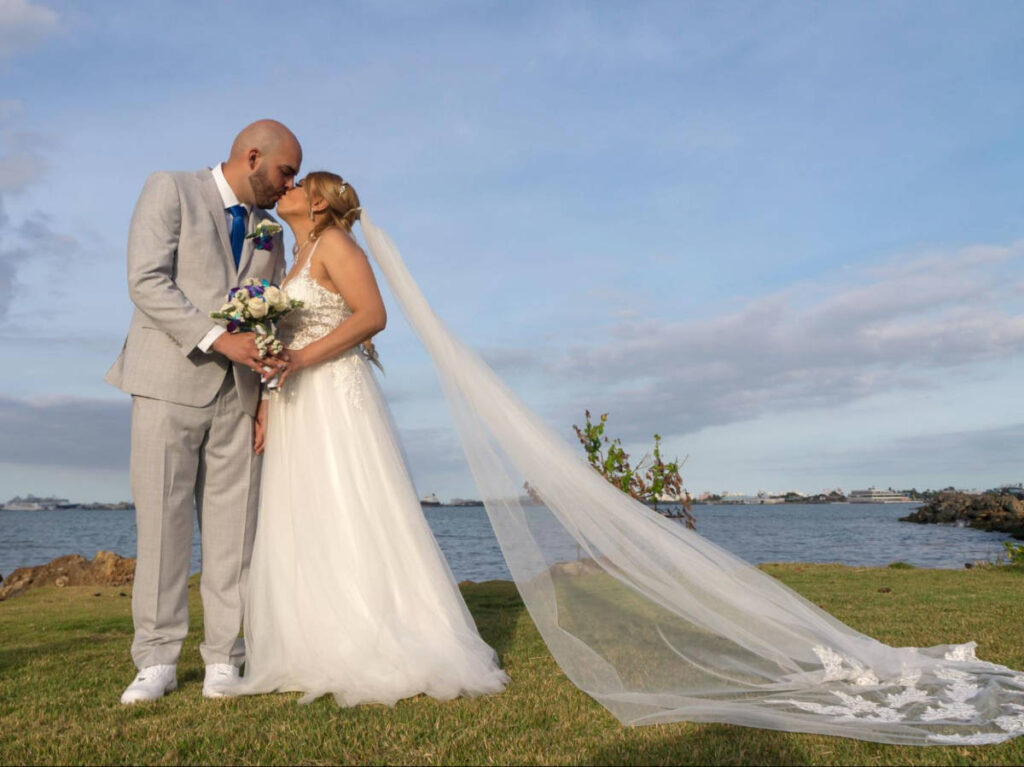 A newly wedded couple kissing with an overlooking view in the background