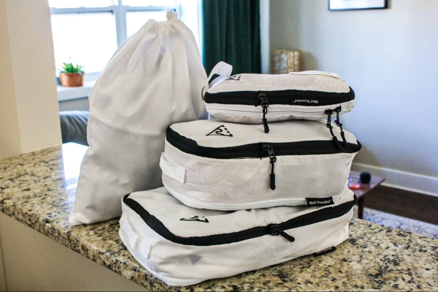 Four multiple sizes of Well Traveled Packing Cubes on the counter