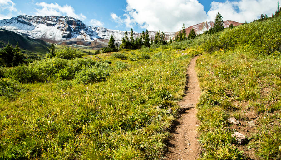 A trail in the West Maroon Pass with a scenic view of the valleys