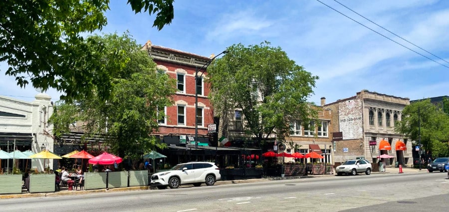 Parked cars on the street outside the restaurants and shops lined up on W Division Street