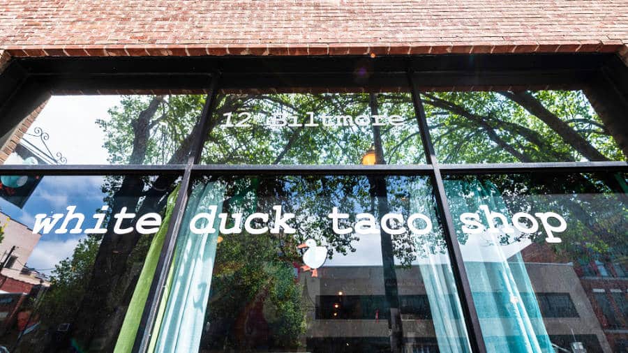 View of the shop name on the glass window of White Duck Taco Shop
