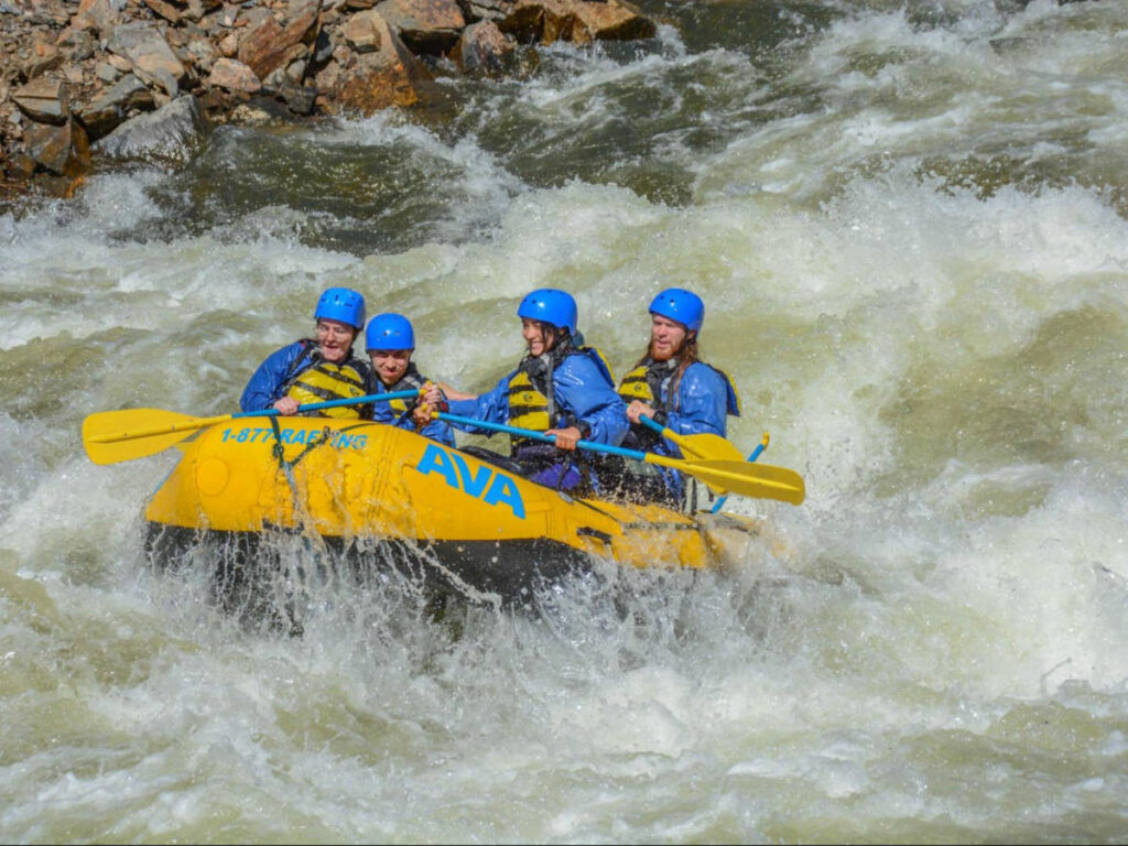 The author Abigail with family and a friend whitewater rafting down Clear Creek