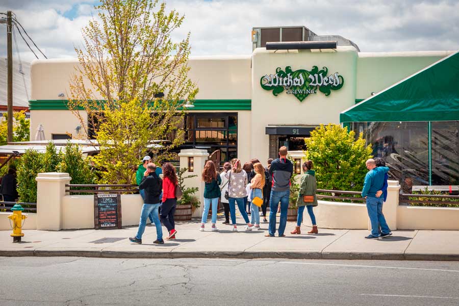 View of people outside the Wicked Weed Brewing Pub
