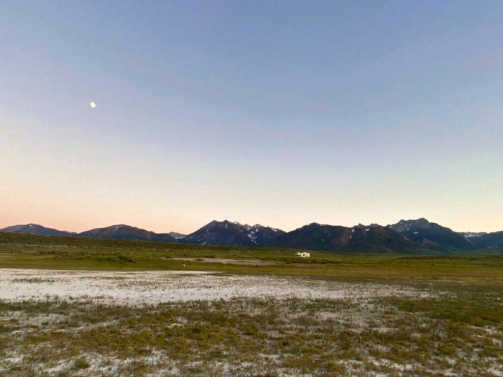 Picturesque view of the moon over the mountain ranges at dusk