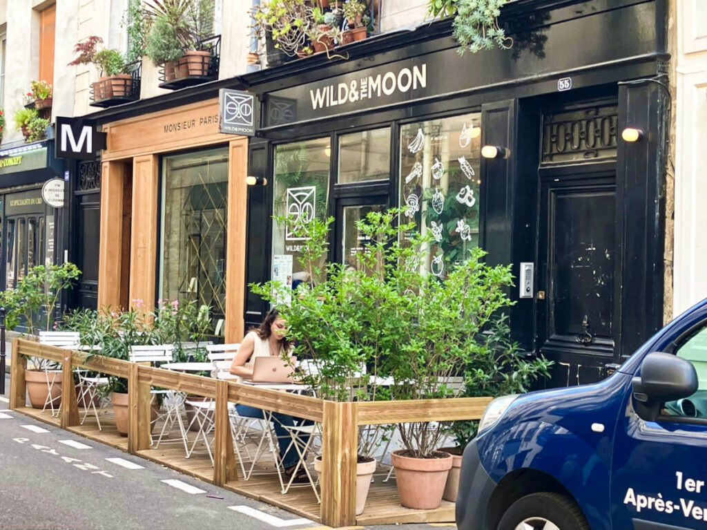 A woman working at the cozy terrace of Wild & the Moon