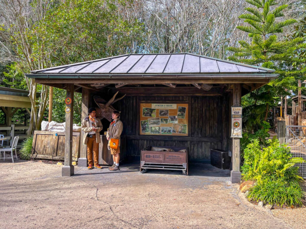 Two people standing outside a stand for the Wilderness Explorer activities