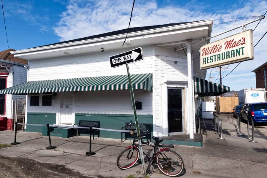 Exterior view of the Willie Mae's Restaurant with a parked bicycle in the "One Way" Post
