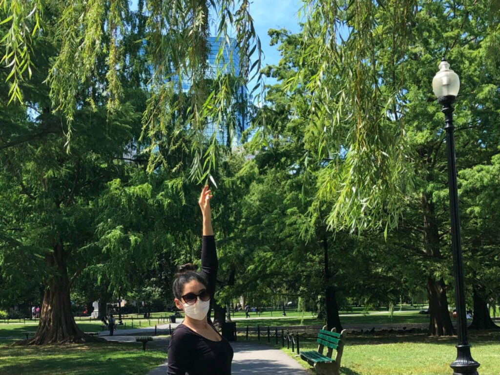 Author Claudicet Pena posing underneath the willow trees in the Boston Public Garden